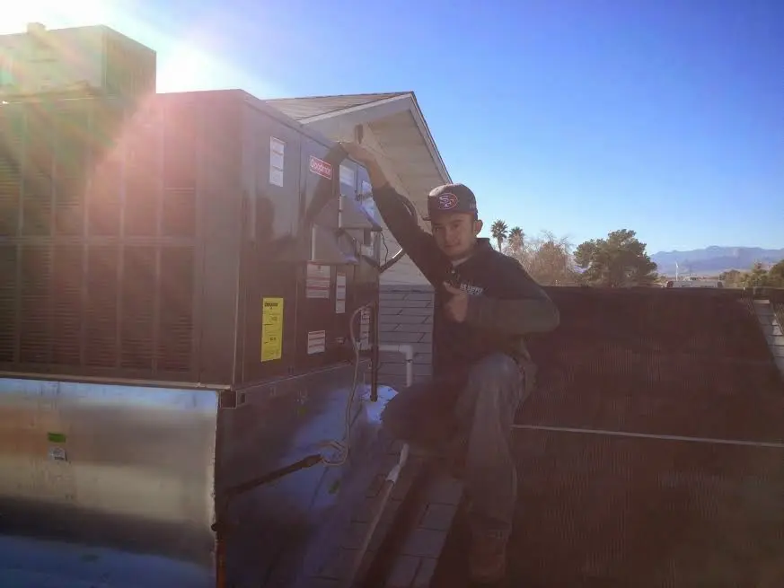 HVAC technician performing HVAC Inspection on a rooftop unit in Alexandria